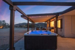 a hot tub under a pergola next to a house at Ranch House with Lap Pool Biking & Running Course in Desert Hot Springs