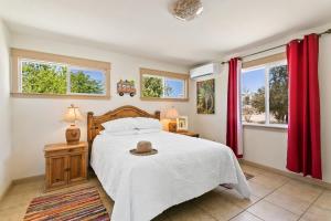 a bedroom with a bed and two windows at Ranch House with Lap Pool Biking & Running Course in Desert Hot Springs