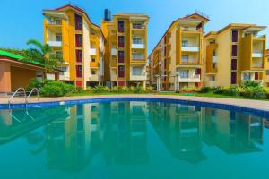果阿旧城FabHotel Ocean View Apartment - Nr Dabolim Airport的部分公寓大楼前的游泳池