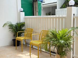 two chairs sitting on a balcony with plants at Miq Asoke 5BR Sukhuvit15 in Makkasan