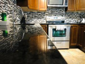 a kitchen with a stove and a counter top at Cozy 2 Bedroom Condo with Parking in Calgary +2 photos
