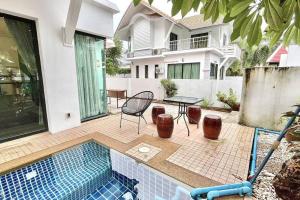 una casa con piscina, tavolo e sedie di h6市中心 唐人街 航站楼 风月街五房芭提雅海天-泳池别墅o a Centro di Pattaya