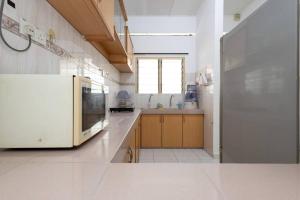 cocina grande con nevera blanca y ventana en Homie4u - Ipoh Garden East 8 pax, en Ipoh
