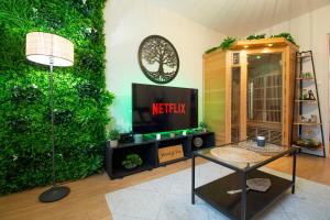 ein Wohnzimmer mit einem TV und einer grünen Wand in der Unterkunft Wood & Sea I Sauna & Hyper centre in Crozon