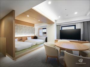 a hotel room with two beds and a table with a television at Daiwa Roynet Hotel Yokohama-Koen in Yokohama +34 photos