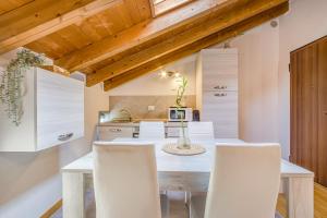a kitchen with a dining table and white chairs at Stazione a 200m - Centro - Easy Parma Stay in Parma