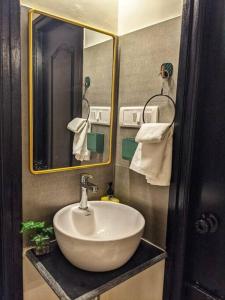un bagno con un lavandino bianco e uno specchio di Pednekar's House, 1BHK with pool by SneekoStays a Nerul