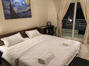 una camera da letto con un letto con due asciugamani sopra di Pednekar's House, 1BHK with pool by SneekoStays a Nerul