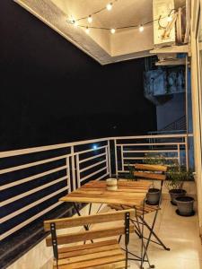un tavolo e sedie di legno su un balcone di Pednekar's House, 1BHK with pool by SneekoStays a Nerul