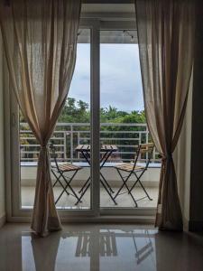 un balcone con tavolo e sedie fuori da una finestra di Pednekar's House, 1BHK with pool by SneekoStays a Nerul