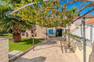 einen Gehweg vor einem Haus mit einer Palme in der Unterkunft Holiday House Maja in Privlaka with barbecue and private garden - by TA Leut Agency in Privlaka