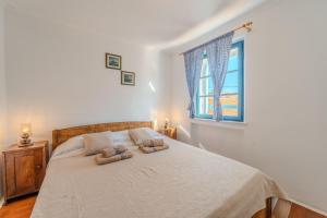 ein Schlafzimmer mit einem Bett mit zwei Kissen darauf in der Unterkunft Holiday House Maja in Privlaka with barbecue and private garden - by TA Leut Agency in Privlaka