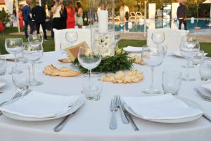 a table with white plates and wine glasses at Locanda Da Renzo in Siamaggiore +61 photos