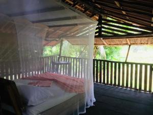 a bed on a porch with a canopy at Eco Lodge Safari in Karuwalagaswewa
