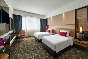 una camera d'albergo con due letti e una televisione di Wyndham Acmar Klang a Klang