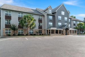 a large building with a palm tree in a parking lot at Country Inn & Suites by Radisson, Columbia Airport, SC in Columbia