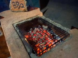 a grill with a bunch of hot dogs cooking at Eco Lodge Safari in Karuwalagaswewa