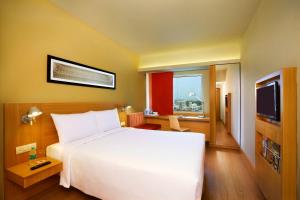 a hotel room with a bed and a television at ibis Chennai City Centre - An Accor Brand in Chennai