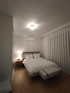 a bedroom with a white bed and a lamp at Kervan Saray Loft apartment in Kérynia