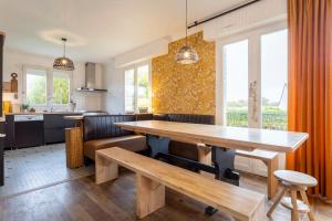 a kitchen and dining room with a wooden table at Maison Valérie à 1km plage in Trégunc