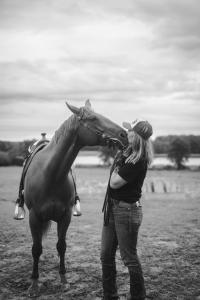 a woman is standing next to a horse at Ulvsby Ranch Western Camp in Karlstad