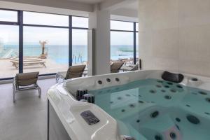 a bath tub in a room with a view of the ocean at Scorpios in Infinity Pool & Spa Resort in Mamaia Sat/Năvodari