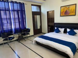 a bedroom with a bed and two chairs in it at New Hotel Blue Moon in Jaipur