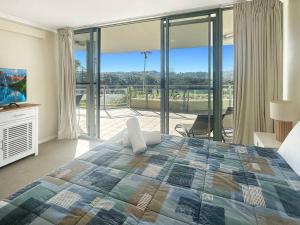 una camera da letto con un letto grande e un balcone di Unit 24 - Avoca Palms Resort ad Avoca Beach