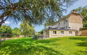 una casa grande en un patio de césped con un árbol en Gîte Le Chêne pommier proche Honfleur, en Fatouville-Grestain