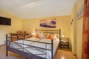 a bedroom with a bed with orange pillows at Ferienwohnung Alpenrose in Bad Reichenhall