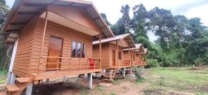 a row of wooden houses in a forest at Konglor Cave Resort-Riverside Restaurant in Ban O