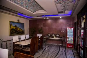 a dining room with a table and a refrigerator at New Hotel Blue Moon in Jaipur
