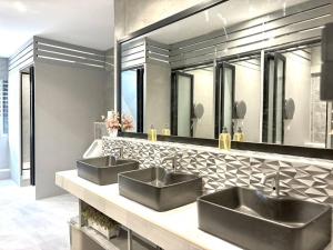 ein Badezimmer mit zwei Waschbecken und einem großen Spiegel in der Unterkunft Nonoteru Chiangmai in Chiang Mai