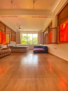 a large living room with a couch and a large window at Wooden Villa in Kanchipuram