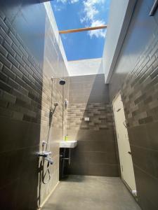 a bathroom with a shower and a sink and a window at Wooden Villa in Kanchipuram