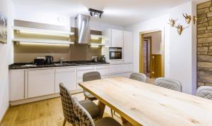 kuchnia z drewnianym stołem i krzesłami w obiekcie Bolodges Apartments by Alpin Rentals w Saalbach Hinterglemm