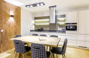 - une cuisine avec une table et des chaises en bois dans l'établissement Bolodges Apartments by Alpin Rentals, à Saalbach-Hinterglemm
