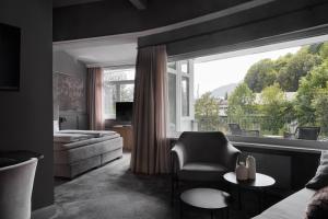 キッツビュールにあるERIKA Boutiquehotel Kitzbühelのソファと大きな窓のあるリビングルーム