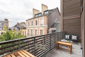 a balcony with a bench and a view of buildings at L'Orée Des Lices - Appt de standing à Rennes in Rennes