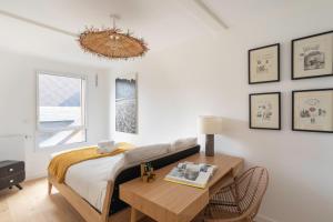 a bedroom with a bed and a table and a window at L'Orée Des Lices - Appt de standing à Rennes in Rennes