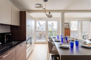 a kitchen with a dining table with blue glasses on it at L'Orée Des Lices - Appt de standing à Rennes in Rennes +7 photos