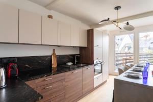 a kitchen with white cabinets and a black counter top at L'Orée Des Lices - Appt de standing à Rennes in Rennes