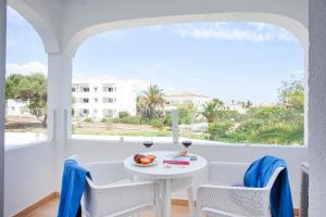 a white balcony with a white table and chairs and a window at BJ Apartamentos Europa in Sa Coma