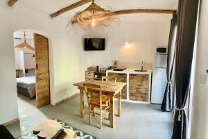 une cuisine et une salle à manger avec une table et un réfrigérateur dans l'établissement xenónas appartement avec petite piscine privée, au Grau-dʼAgde