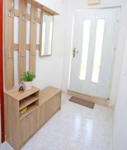 ein Badezimmer mit einem Holzschrank und einer Tür in der Unterkunft Apartment Marija in Drvenik Mali + 26 Fotos