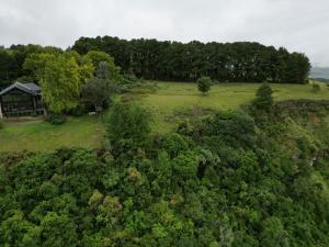 eine Luftaufnahme eines Feldes mit einem Haus und Bäumen in der Unterkunft Drakenzicht KZN in Winterton