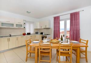 a kitchen and dining room with a wooden table and chairs at House Miho in Omiš