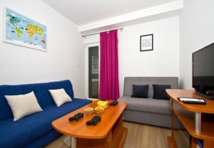 a living room with a blue couch and a table at House Miho in Omiš