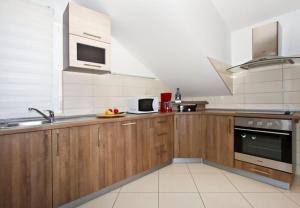 a kitchen with wooden cabinets and stainless steel appliances at House Miho in Omiš