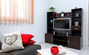 ein Wohnzimmer mit einem Entertainment-Center mit einem TV in der Unterkunft Apartment Marija in Drvenik Mali